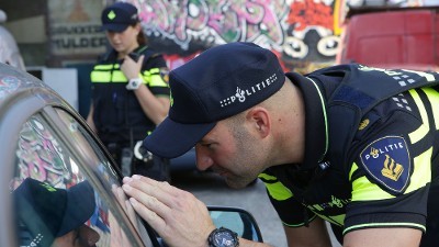 Agenten kijken bij auto naar binnen